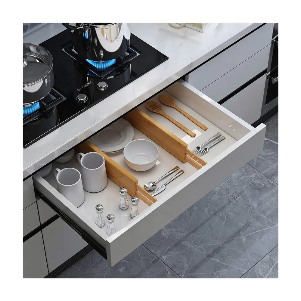 séparateurs de tiroirs en utilisation réelle dans un tiroir de cuisine compartimentant les espaces pour la vaisselle et les ustensiles rangés dans le tiroir