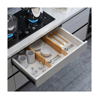 séparateurs de tiroirs en utilisation réelle dans un tiroir de cuisine compartimentant les espaces pour la vaisselle et les ustensiles rangés dans le tiroir